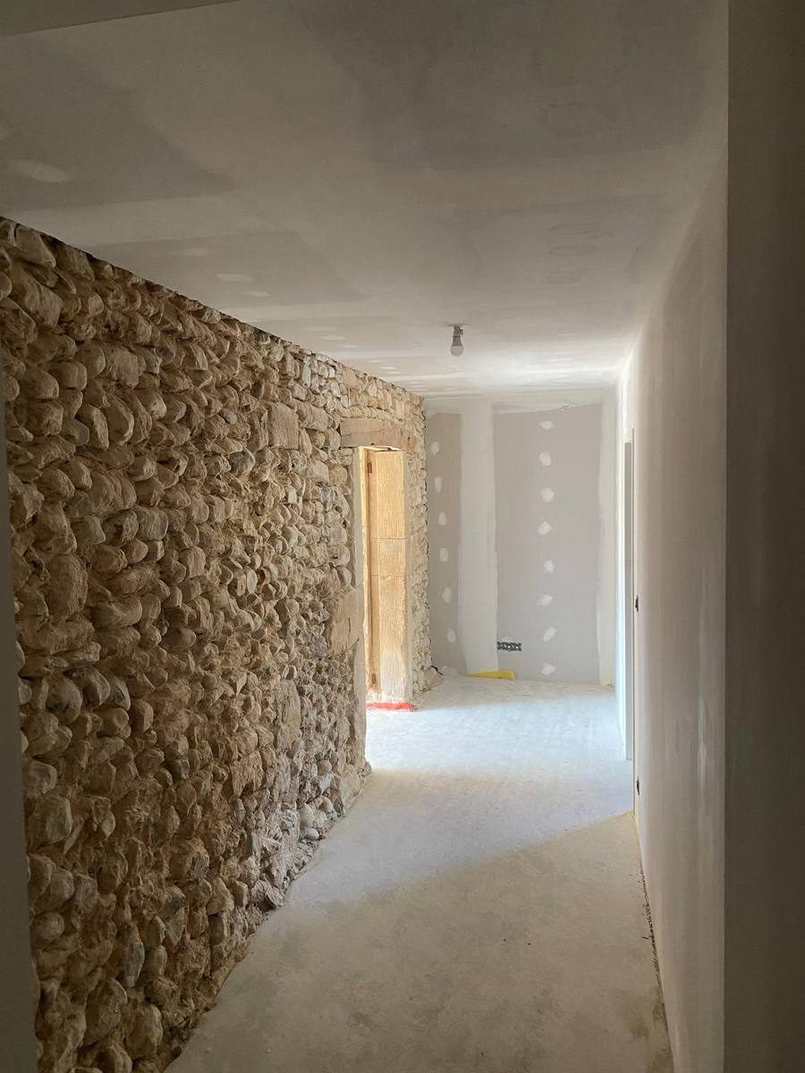 Couloir rénové : cloison en plaques de plâtre face à un mur en pierre apparente – Cabesos & Fils