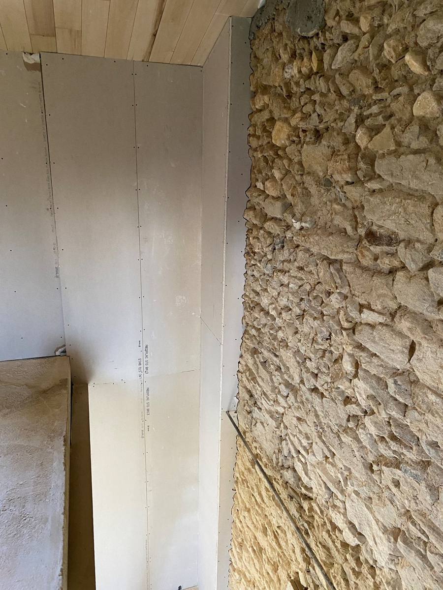 Doublage en plaques de plâtre le long d'un mur en pierre, plafond lambrissé – Cabesos & Fils