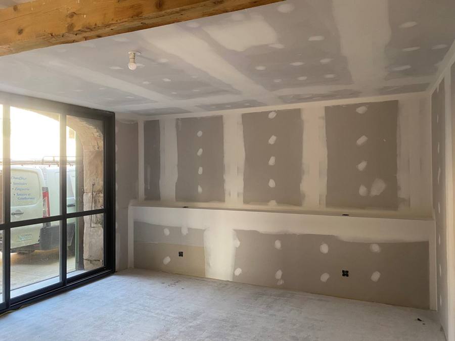 Doublage des murs en plaques de plâtre dans une pièce lumineuse en rénovation – Cabesos & Fils