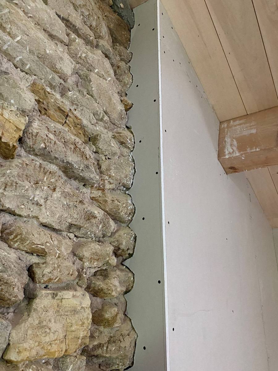 Jonction soignée entre doublage en plaques de plâtre et mur en pierre apparente – Cabesos & Fils