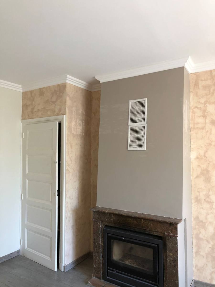 Salon avec cheminée : mur peint teinte taupe et murs décoratifs – Cabesos & Fils
