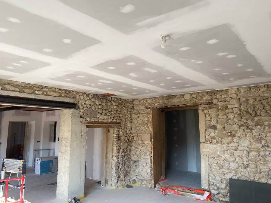 Plafond en plaques de plâtre avec bandes, murs en pierre apparente conservés – rénovation dans la Drôme – Cabesos & Fils